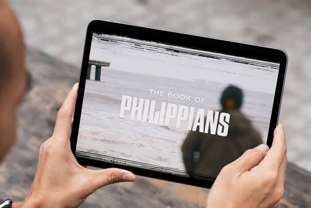 Hands holding a tablet showing The Book of Philippians series