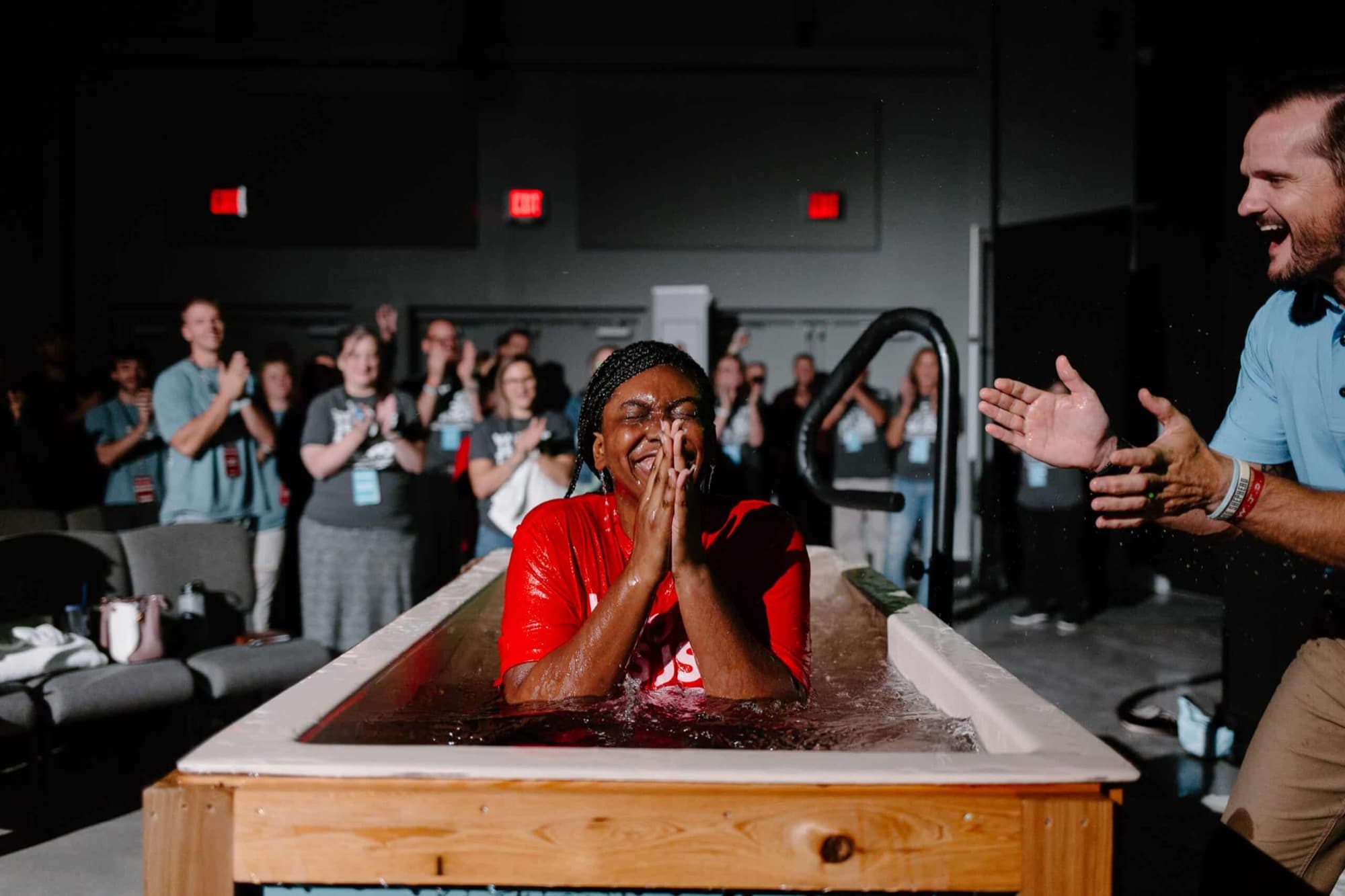 A woman rejoicing at her baptism while the team cheers