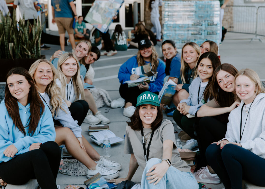 Group of students smiling together at ONE WKND 2026, wearing casual attire and displaying a sense of community and excitement for the event, with a focus on connection and faith.