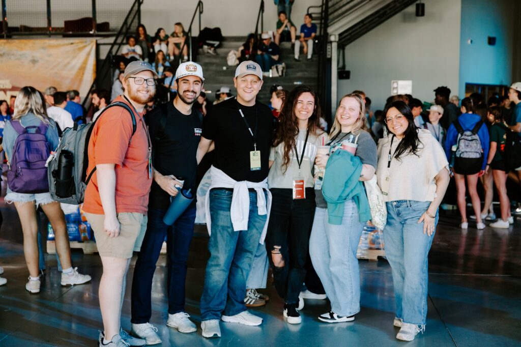 Group of young adults smiling together at ONE WKND 2026 event, showcasing community and connection in a vibrant church setting.