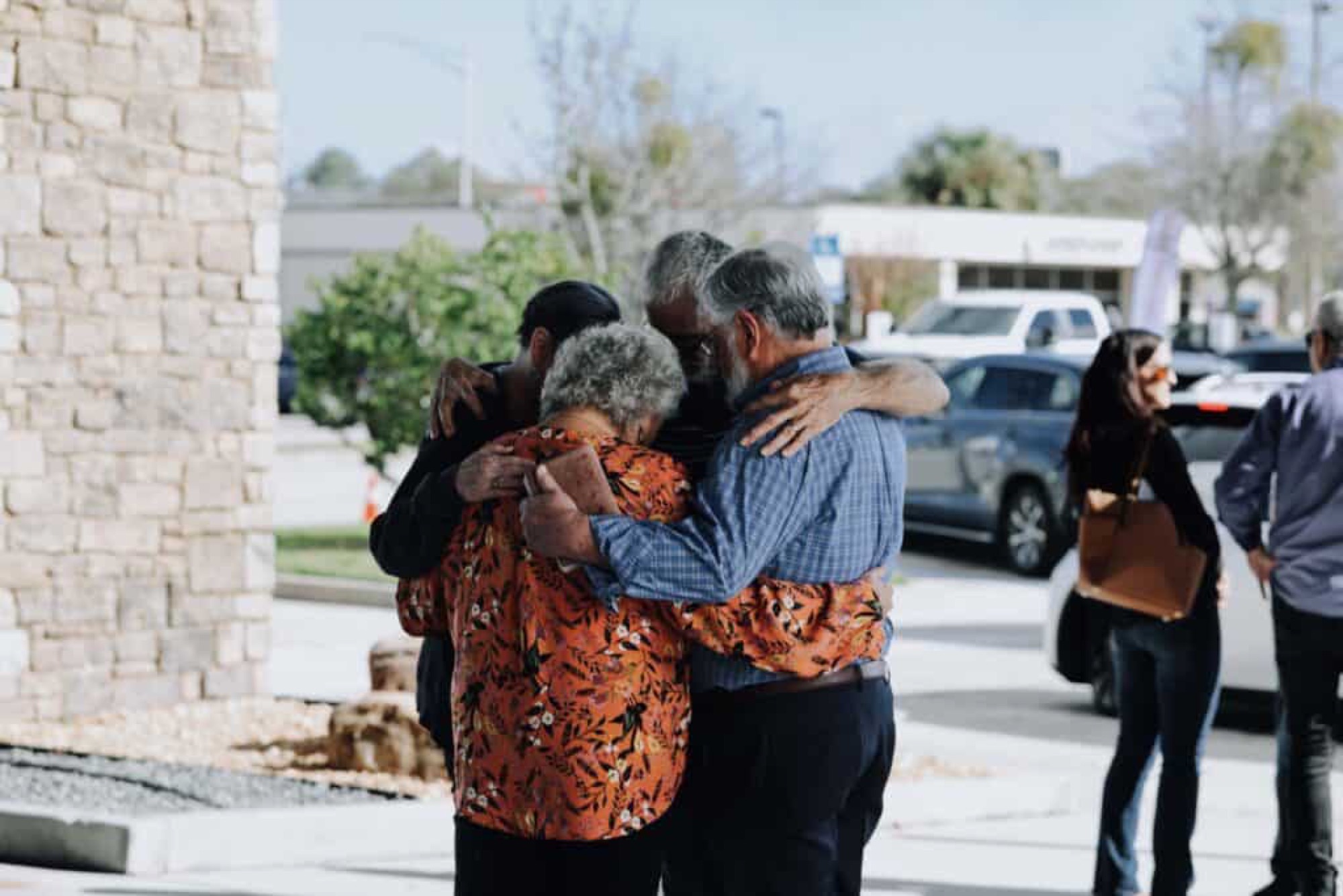 Senior adults praying together in a huddle at Eleven22