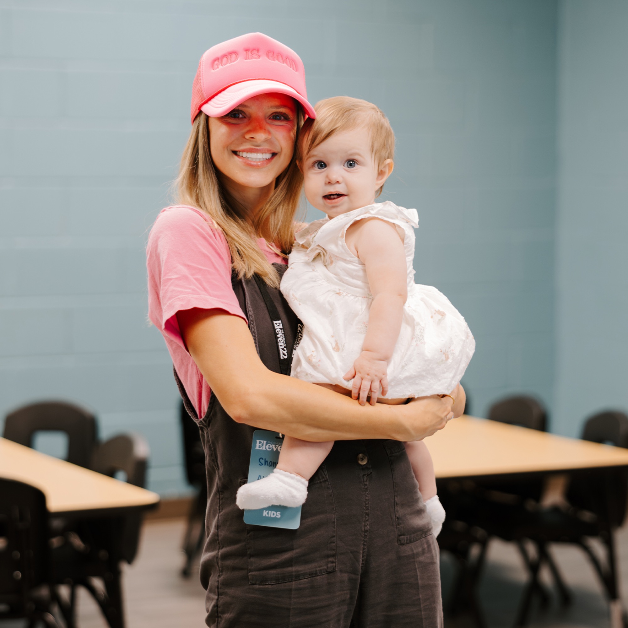 An Eleven22 Kids volunteer holding a baby in a Kids classroom